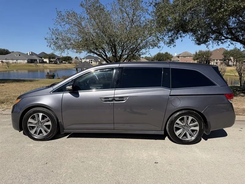 Gray 2015 Honda Odyssey Touring Elite side profile with sliding doors near Houston TX